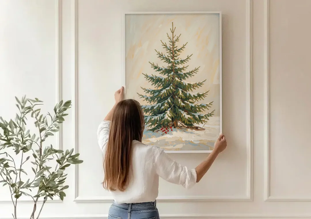 3 Piece Christmas Canvas of a Snowy Young Fir canvas wall art being hung on a paneled wall