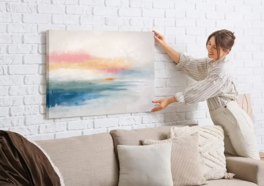 Abstract Art Above Bed with Tangerine Haze canvas wall art being hung on a white brick wall above a sofa