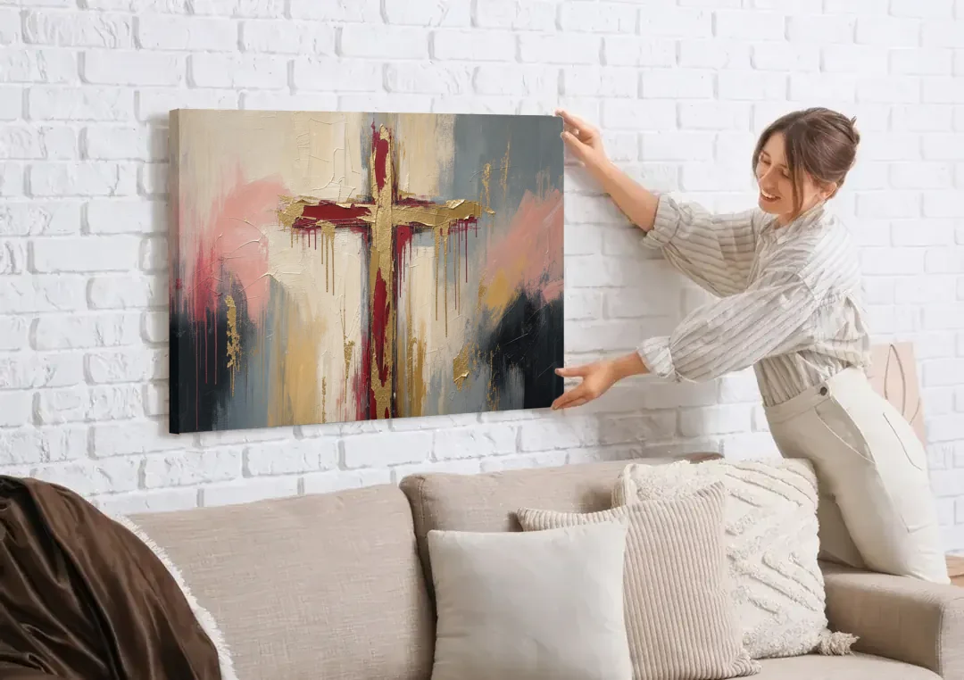 Abstract Cross Painting in Crimson and Gold Leaf canvas wall art being hung on a white brick wall above a sofa
