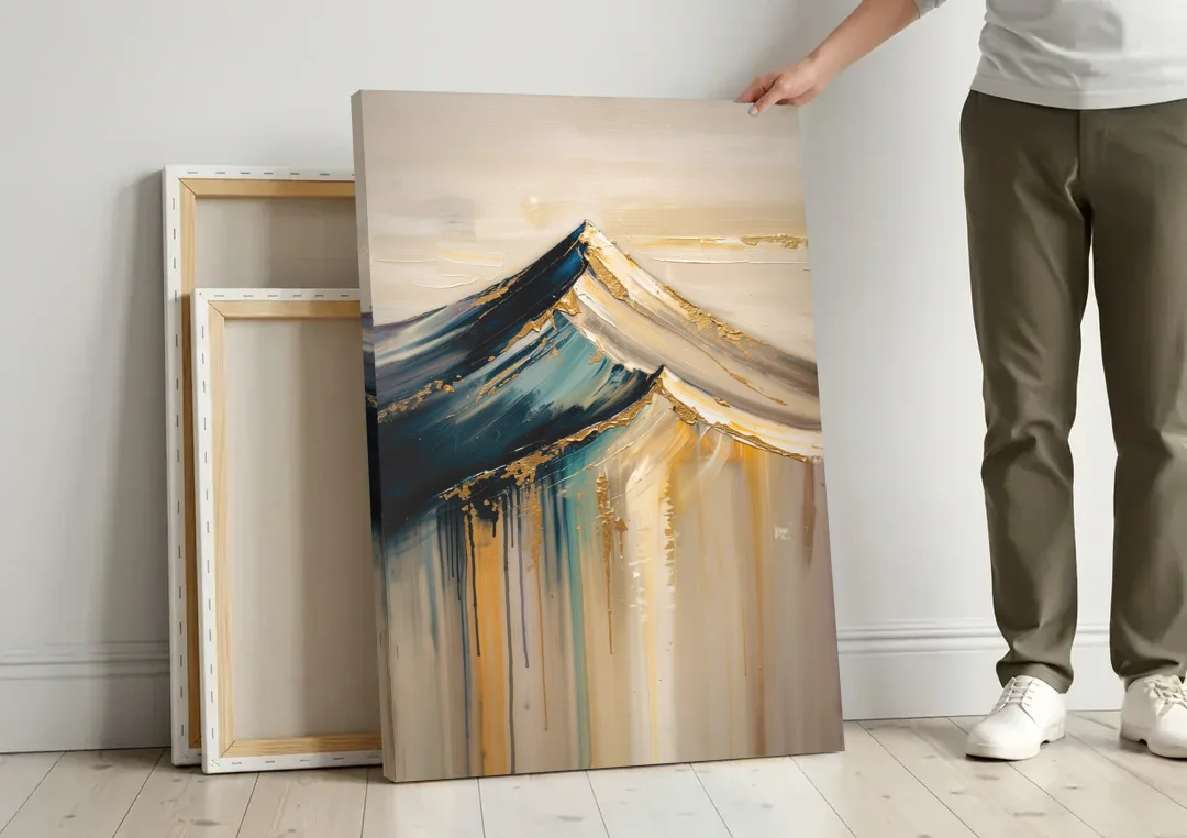Abstract Mountain Painting with Gold Ridgelines canvas wall art leaning against a wall next to blank canvases