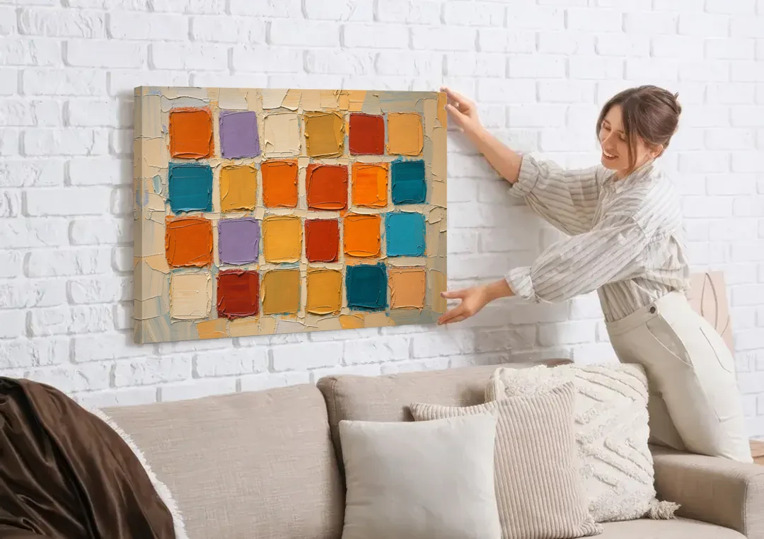 Abstract Orange Knife Tile Grid canvas wall art being hung on a white brick wall above a sofa