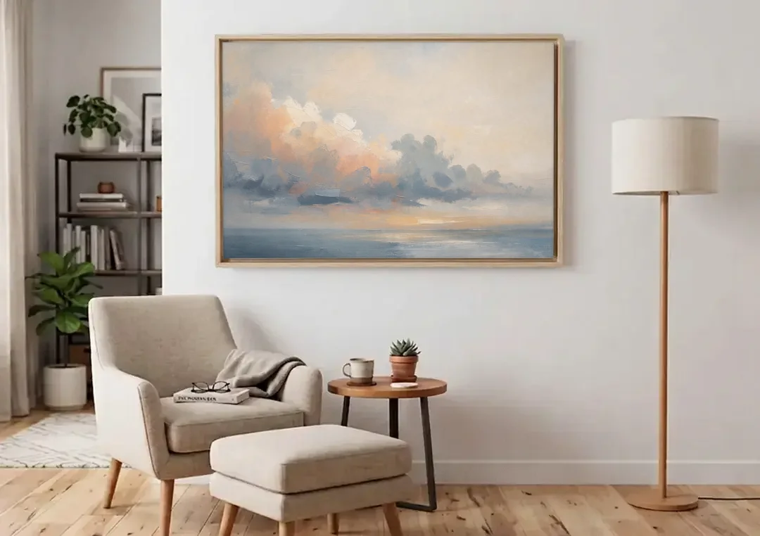 Abstract Sky Painting with Peach Cloud Bank canvas wall art above an armchair in a bright living room