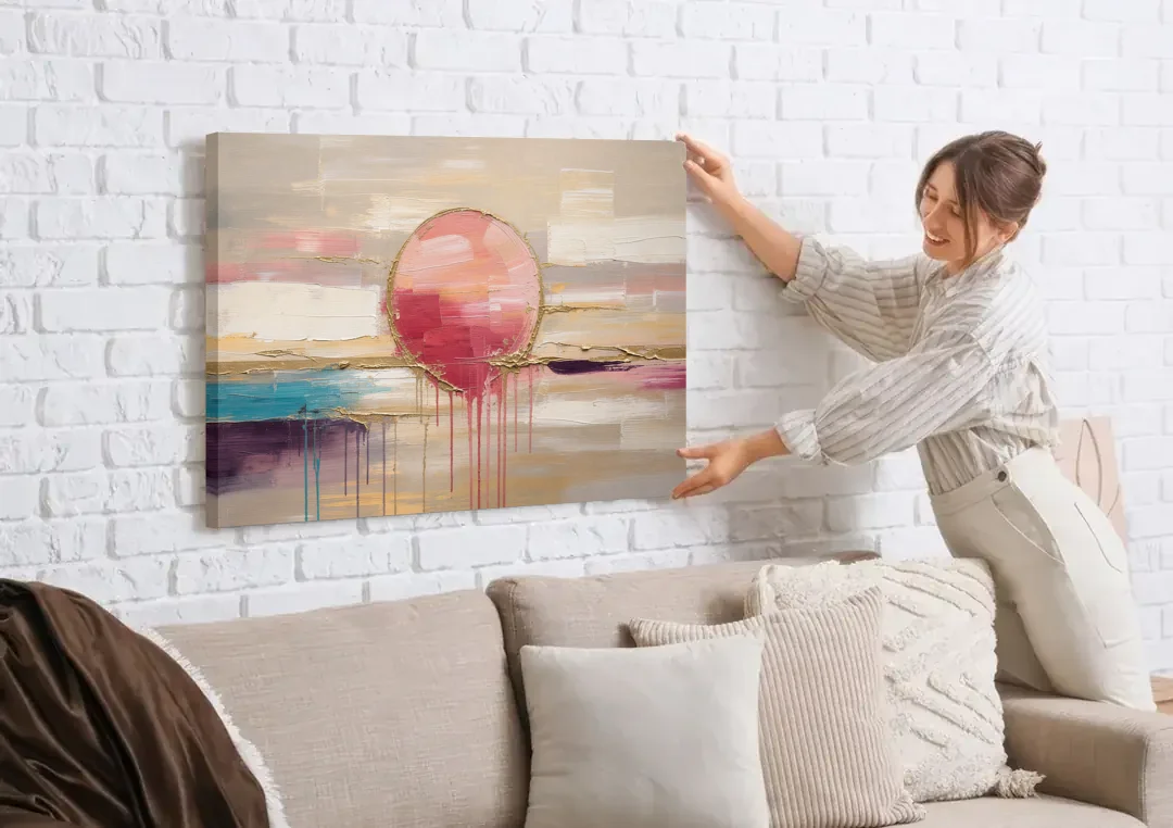 Abstract Sun Painting with Gold Drips canvas wall art being hung on a white brick wall above a sofa