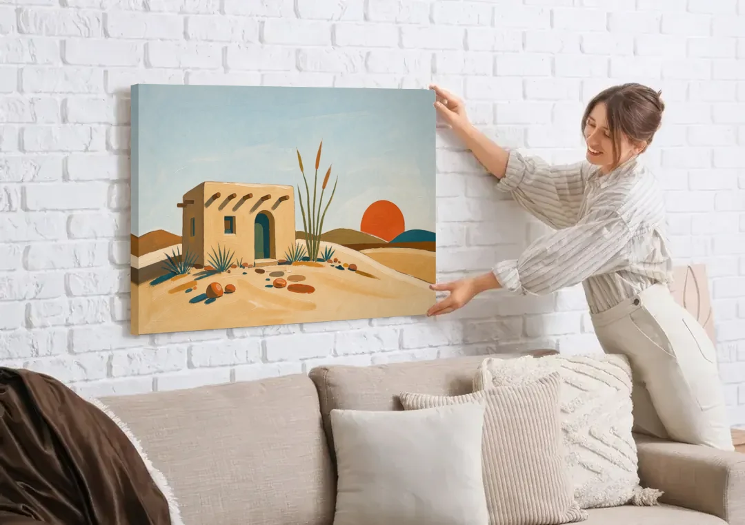 Adobe House Painting at Desert Sundown canvas wall art being hung on a white brick wall above a sofa