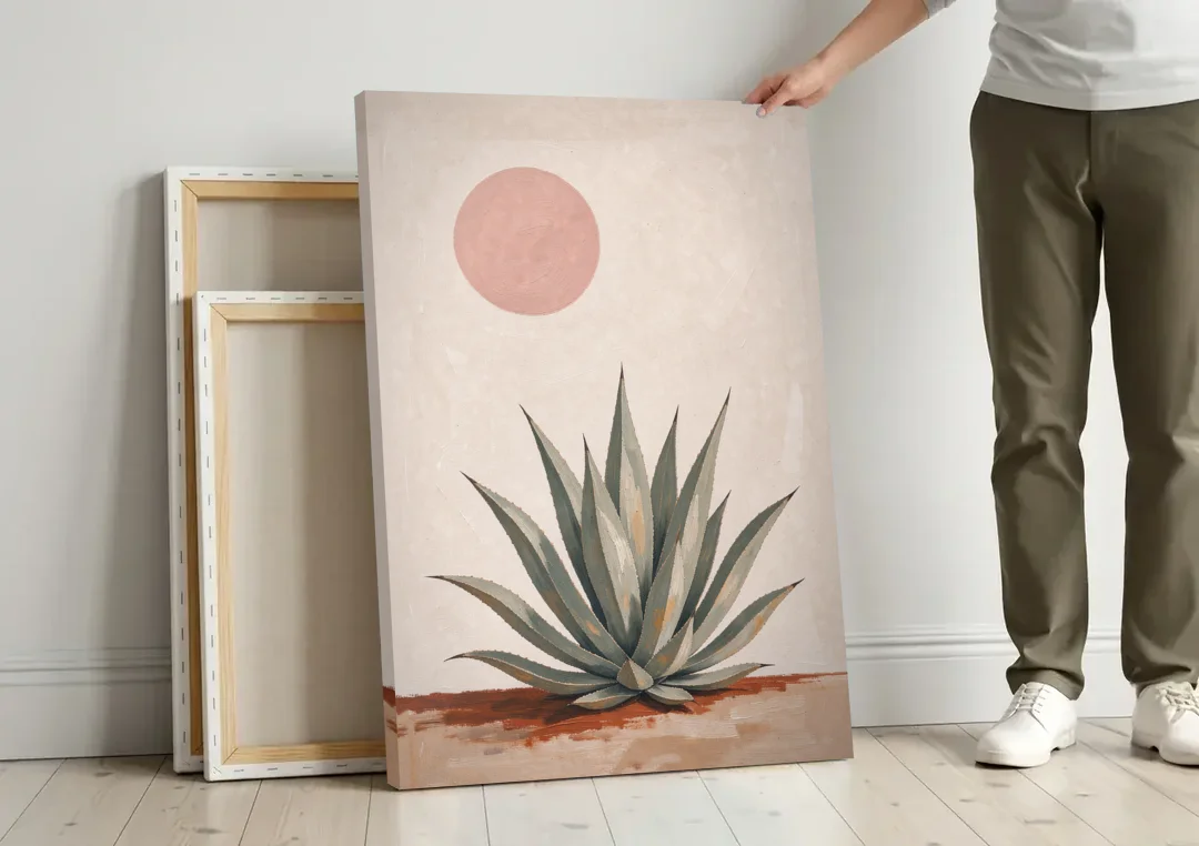 Agave Rosette Under a Blush Pink Sun canvas wall art leaning against a wall next to blank canvases
