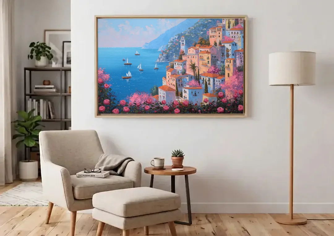 Amalfi Coast Painting with Sailboats canvas wall art above an armchair in a bright living room