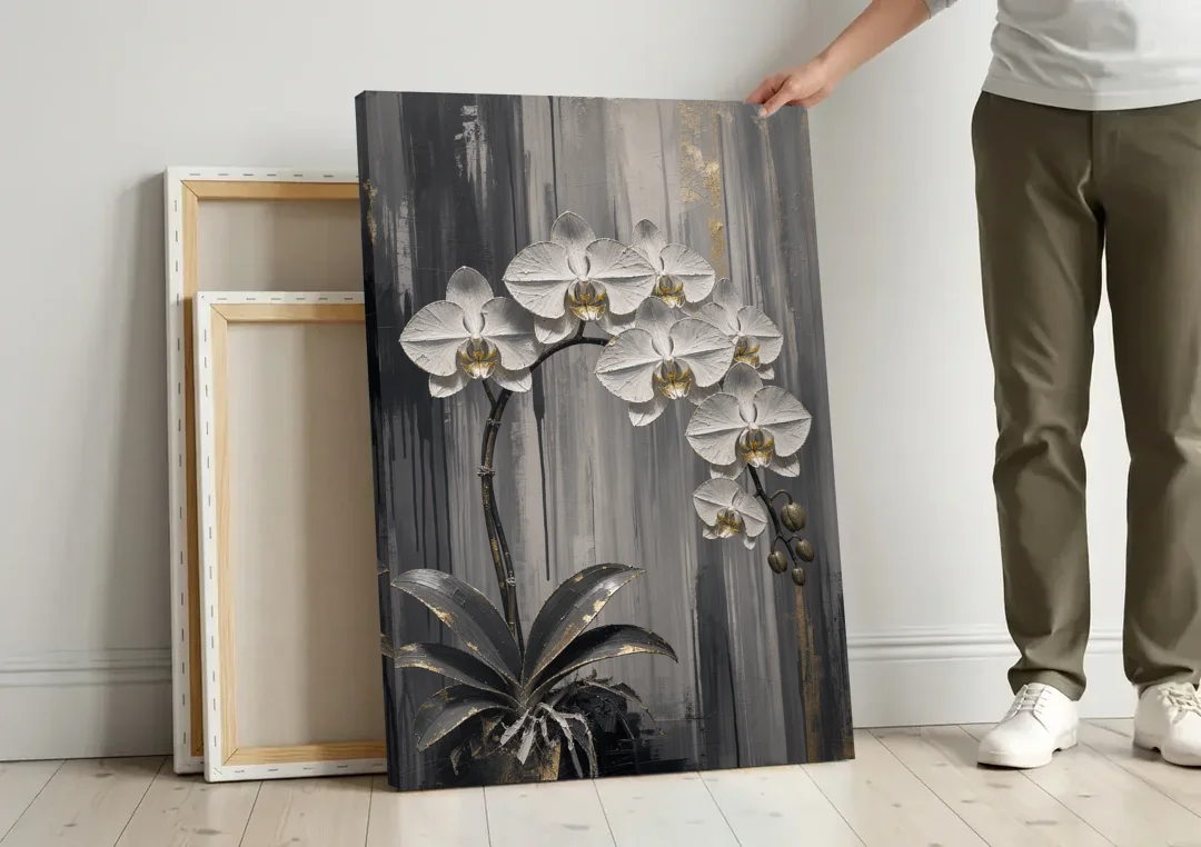 Arching White Orchid Spray with Gold Accents canvas wall art leaning against a wall next to blank canvases