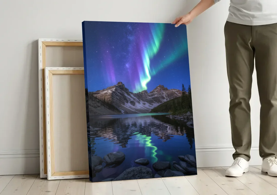 Aurora Mountain Reflection canvas wall art leaning against a wall next to blank canvases