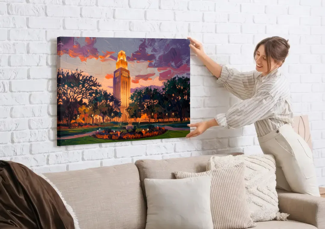 Austin Ut Tower Glow canvas wall art being hung on a white brick wall above a sofa