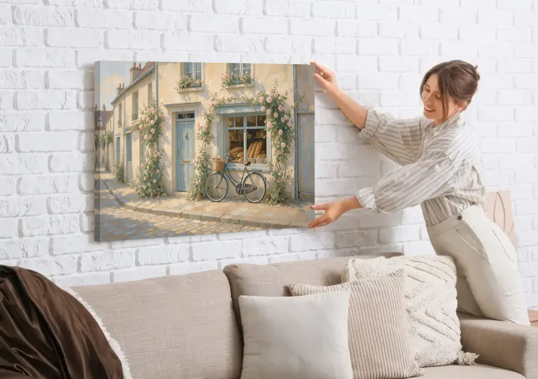 Bakery Painting with Roses and Vintage Bicycle canvas wall art being hung on a white brick wall above a sofa