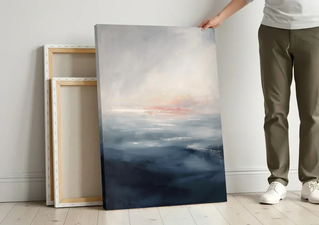 Bathroom Paintings Blush Dawn Over a Misty Sea canvas wall art leaning against a wall next to blank canvases