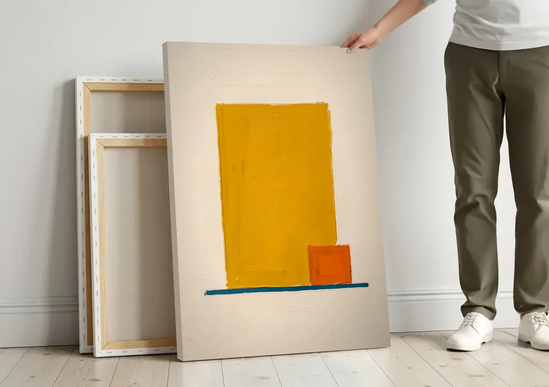 Bauhaus Wall Art with Yellow Block and Orange Square canvas wall art leaning against a wall next to blank canvases