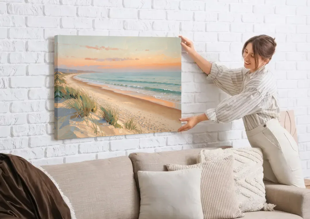 Beach Landscape Painting at First Light canvas wall art being hung on a white brick wall above a sofa