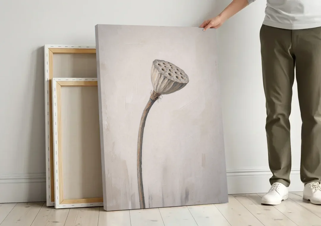 Beige Abstract Canvas Art with a Dried Lotus Pod canvas wall art leaning against a wall next to blank canvases