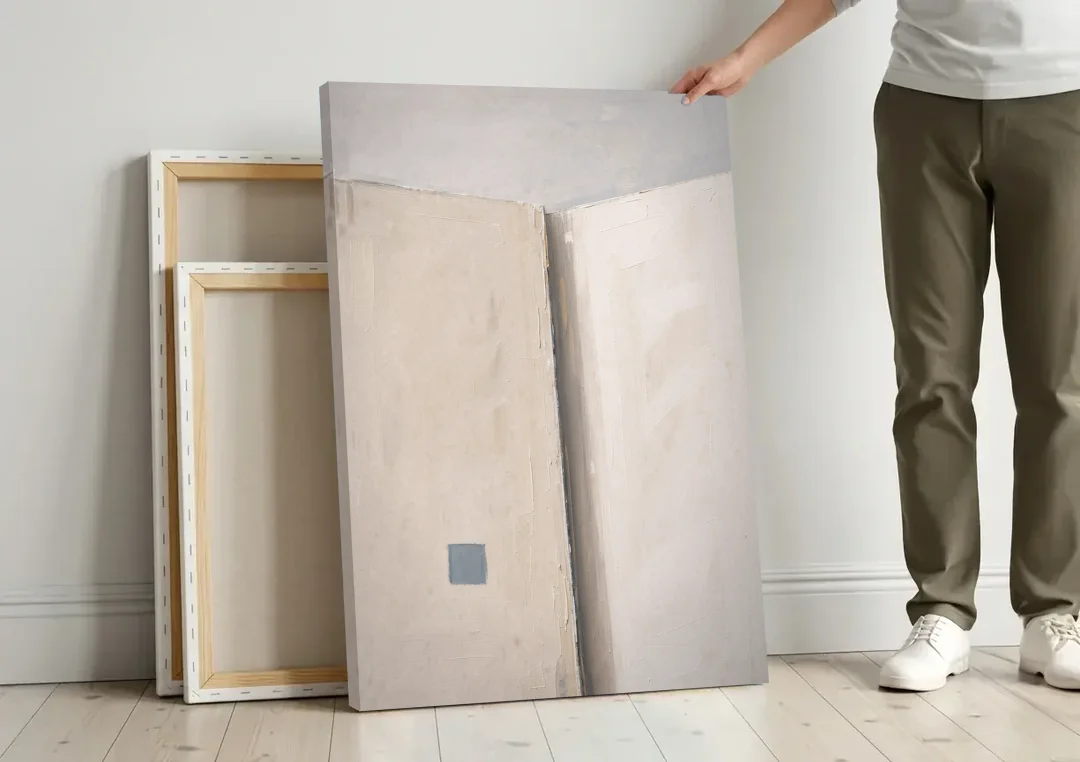 Beige Wall Art Fold with Slate Square canvas wall art leaning against a wall next to blank canvases