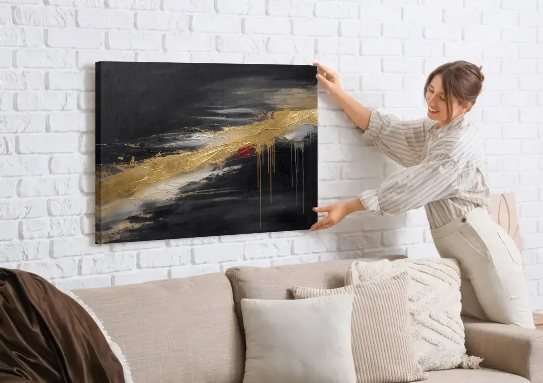 Black and Gold Abstract with Crimson Ember for Dining Rooms canvas wall art being hung on a white brick wall above a sofa