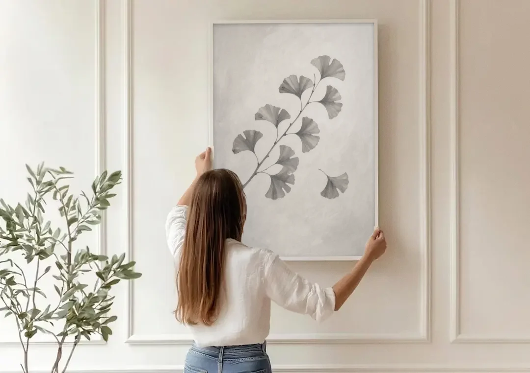 Black and White Bedroom Decor With a Ginkgo Sprig canvas wall art being hung on a paneled wall