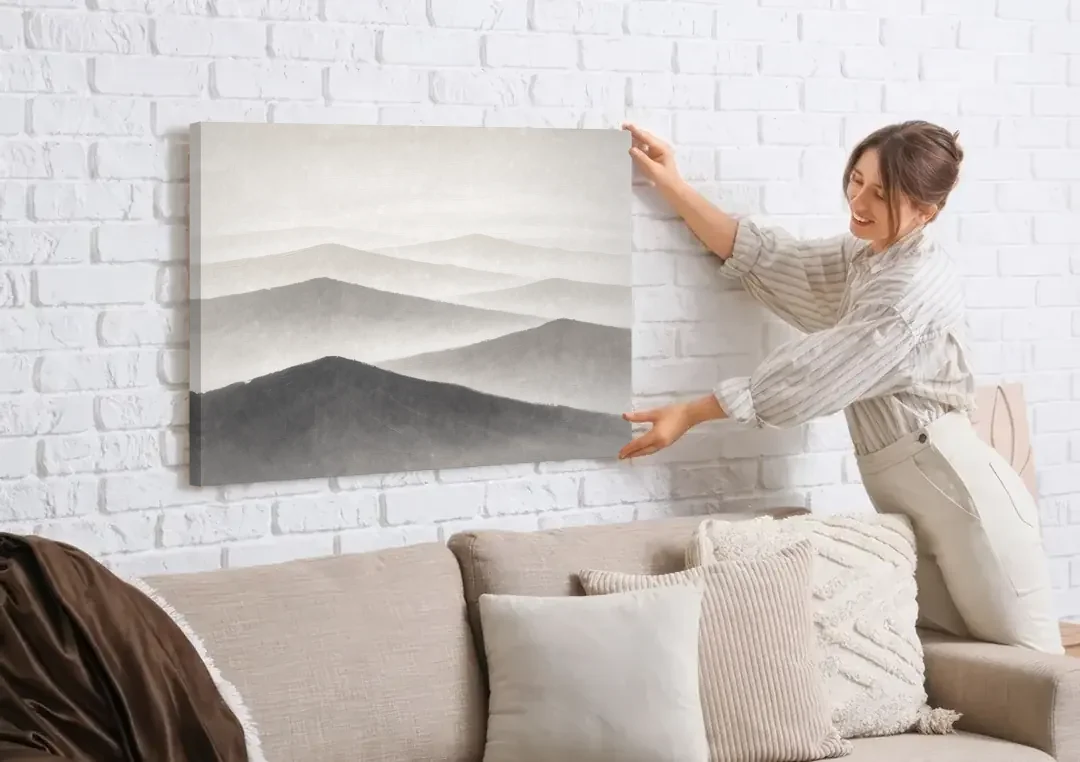 Black and White Bedroom Wall Art of Misty Ridges canvas wall art being hung on a white brick wall above a sofa