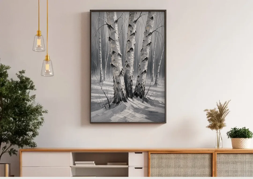 Winter Black and White Birch Trio in Deep Snow canvas wall art above a wooden sideboard under pendant lights