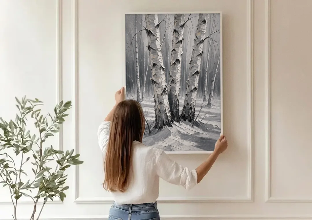 Winter Black and White Birch Trio in Deep Snow canvas wall art being hung on a paneled wall