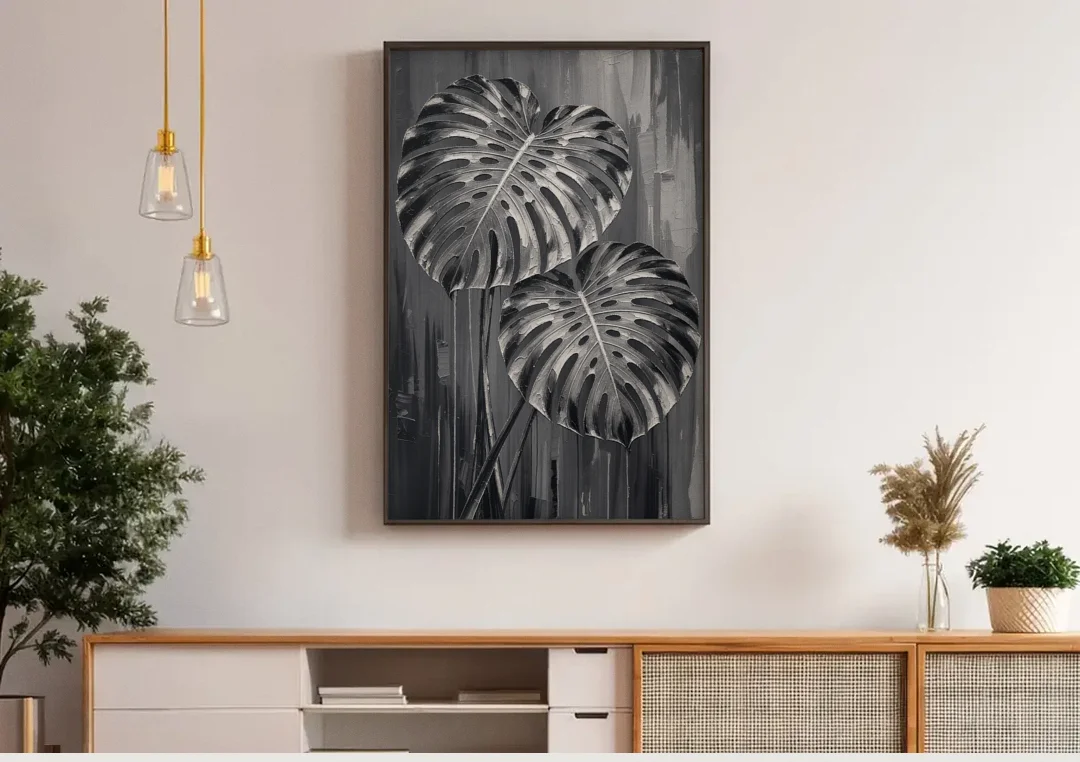 Black and White Botanical Prints Monstera Leaves canvas wall art above a wooden sideboard under pendant lights