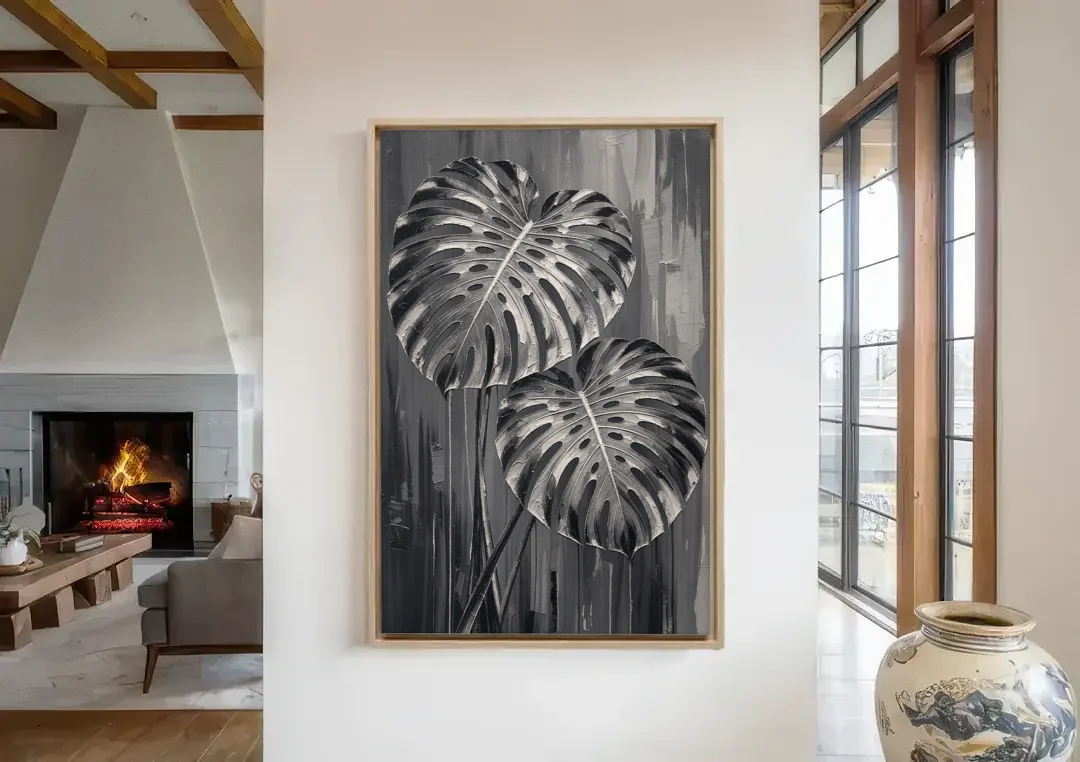 Black and White Botanical Prints Monstera Leaves canvas wall art in a living room with a fireplace