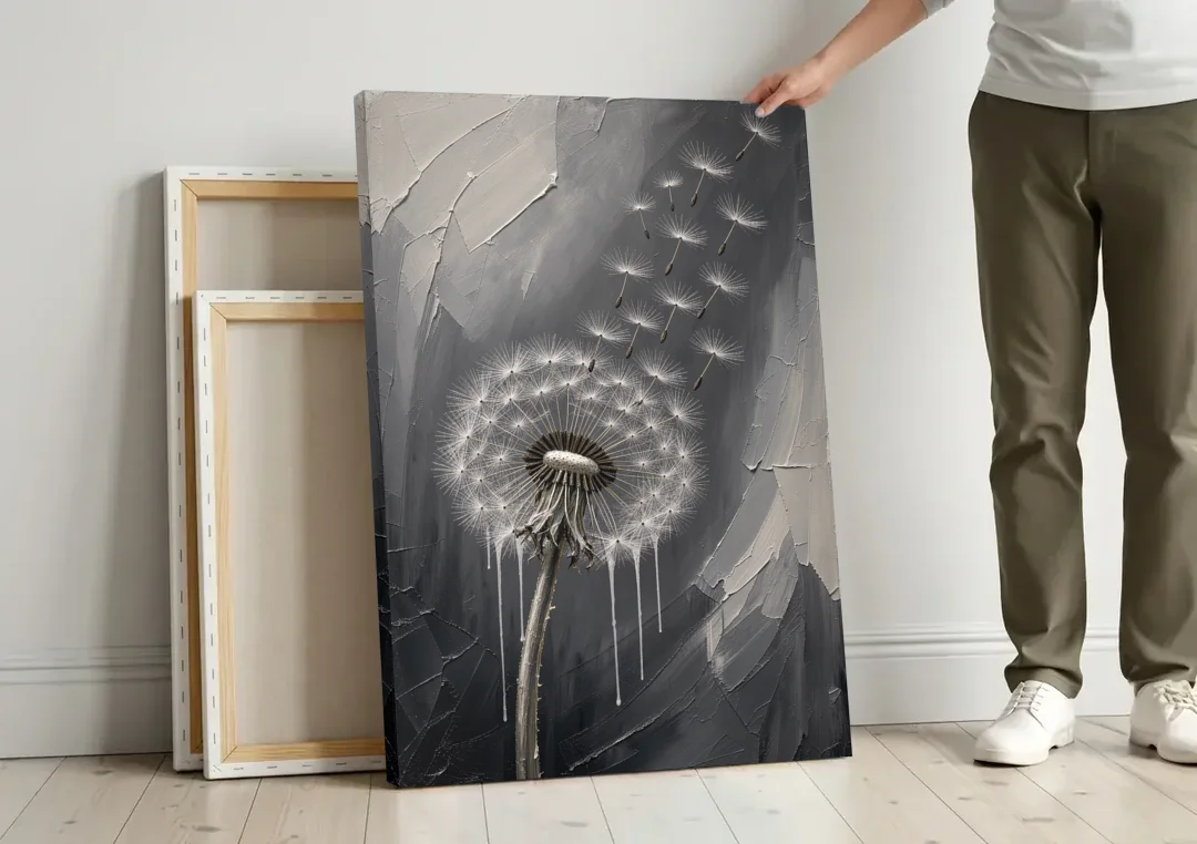 Black and White Canvas Prints with Drifting Dandelion canvas wall art leaning against a wall next to blank canvases