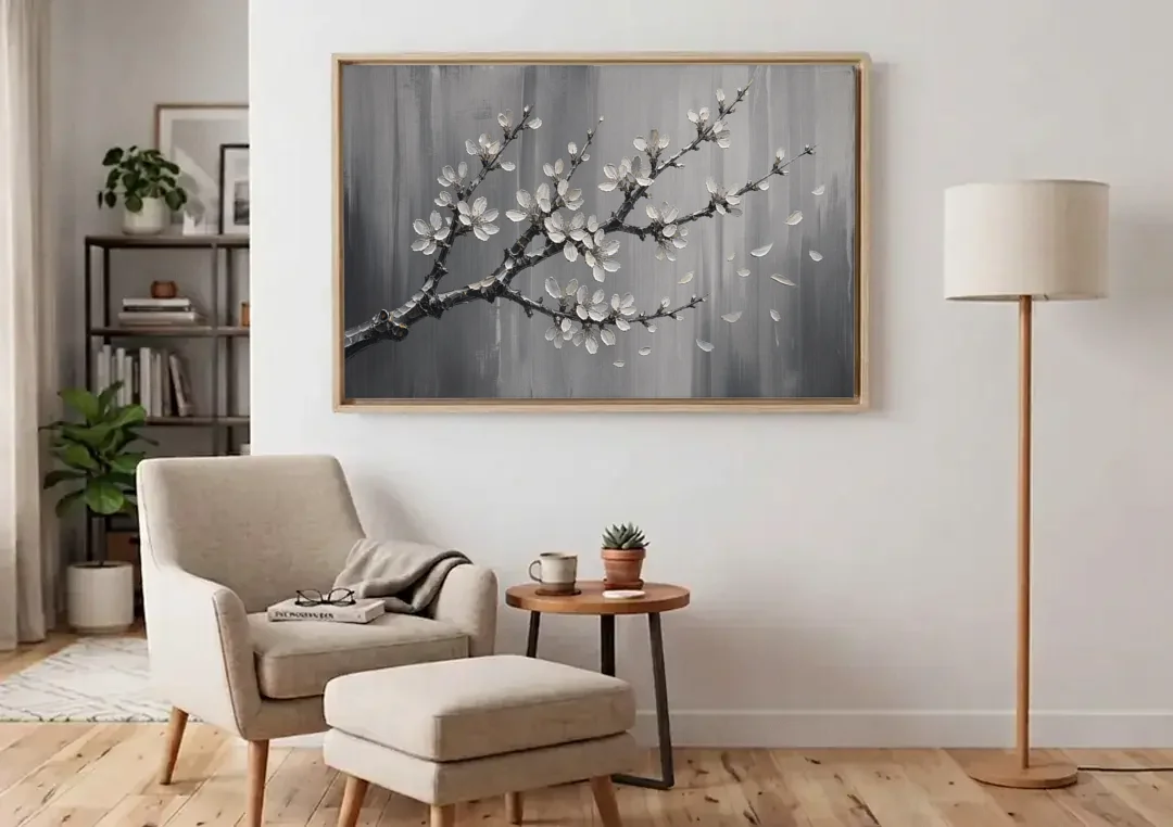 Black and White Cherry Blossom Painting with Drifting Petals canvas wall art above an armchair in a bright living room