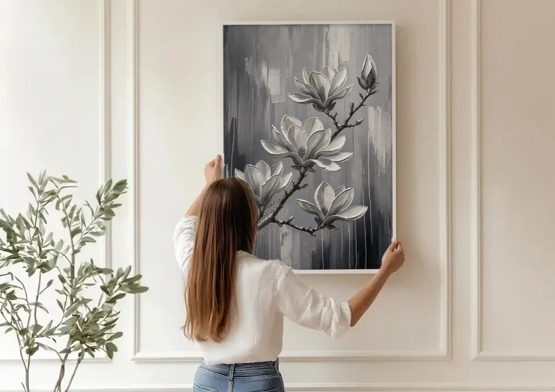 Black and White Floral Canvas of a Magnolia Branch canvas wall art being hung on a paneled wall
