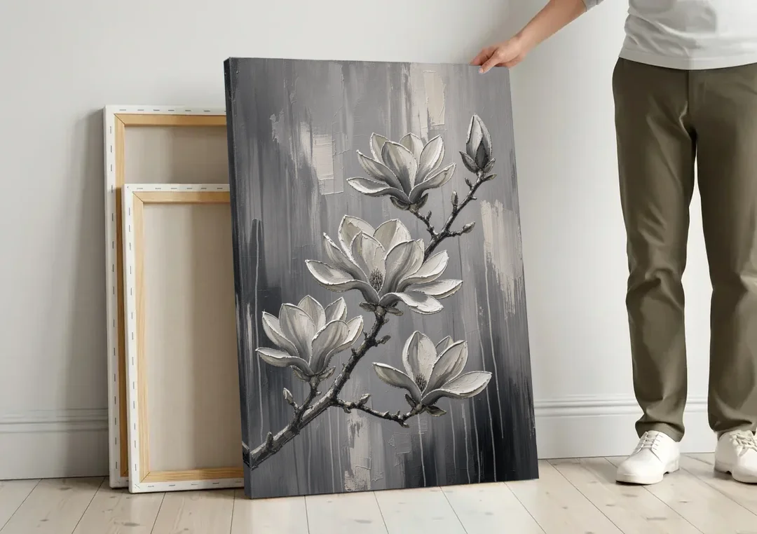 Black and White Floral Canvas of a Magnolia Branch canvas wall art leaning against a wall next to blank canvases