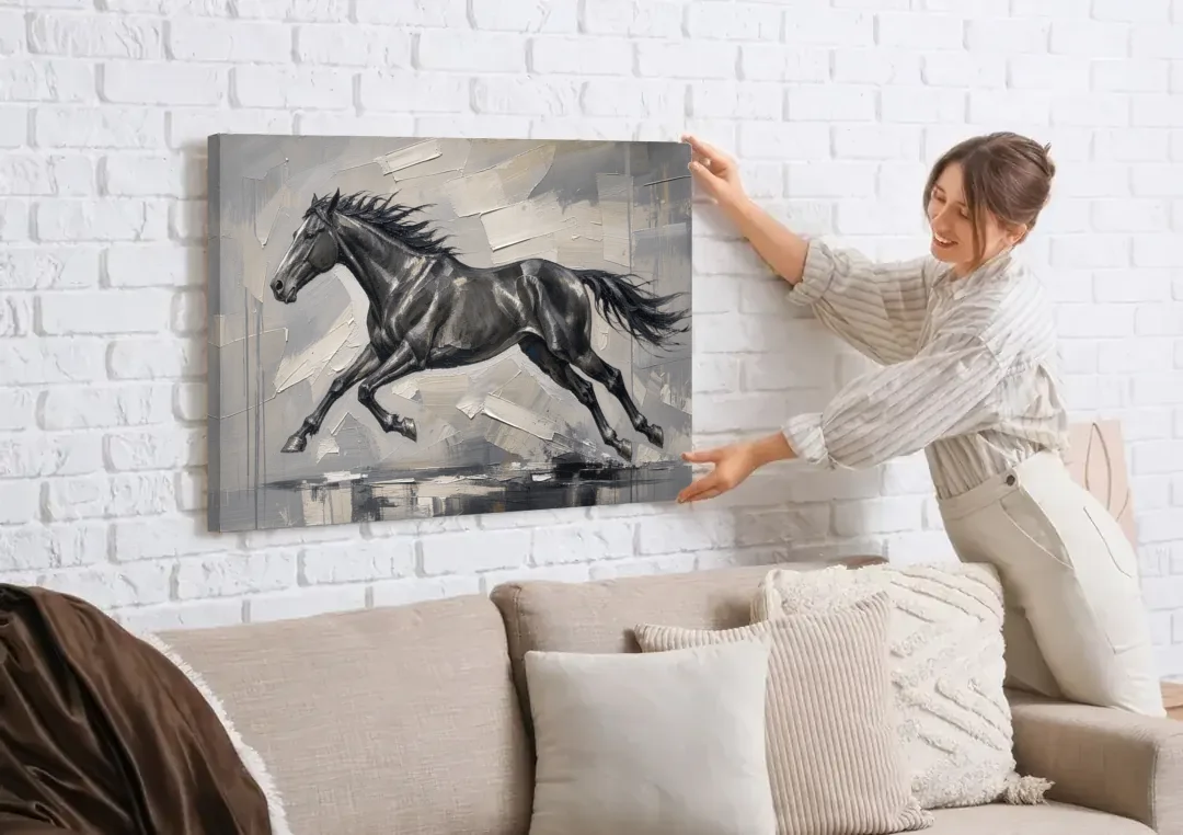 Black and White Horse Painting in Full Stride canvas wall art being hung on a white brick wall above a sofa