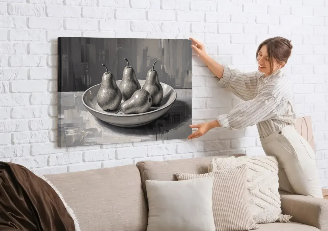 Black and White Kitchen Wall Art of Four Pears canvas wall art being hung on a white brick wall above a sofa