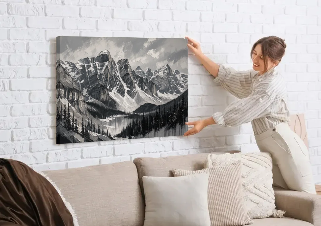 Black and White Landscape Wall Art of Alpine Peaks canvas wall art being hung on a white brick wall above a sofa