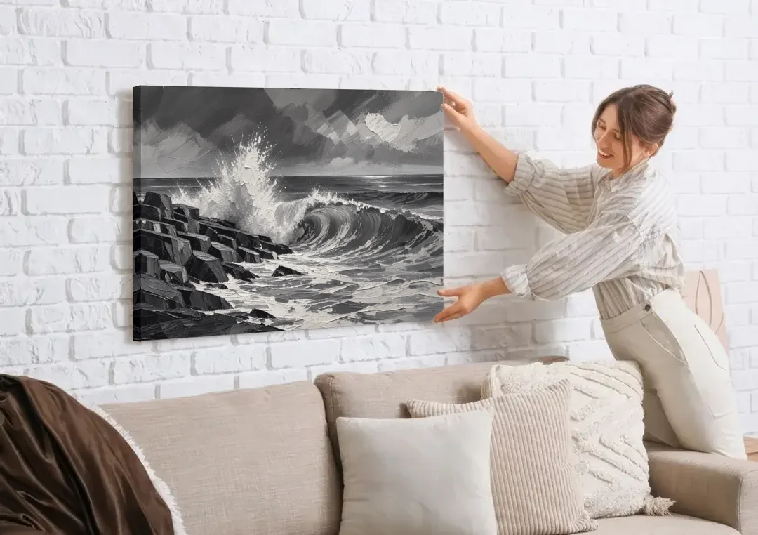 Black and White Paintings of a Crashing Wave canvas wall art being hung on a white brick wall above a sofa
