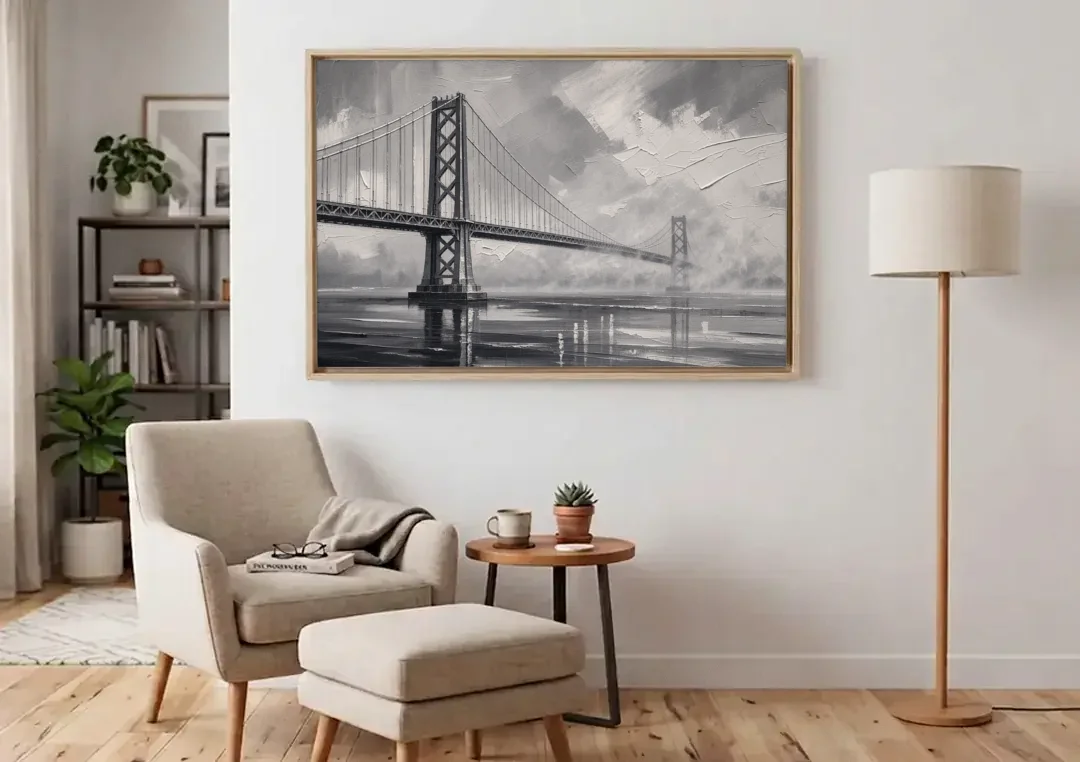 Black and White Panoramic Wall Art of a Bridge canvas wall art above an armchair in a bright living room