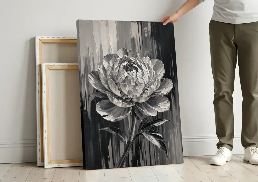 Black and White Peony Wall Art in Full Bloom canvas wall art leaning against a wall next to blank canvases