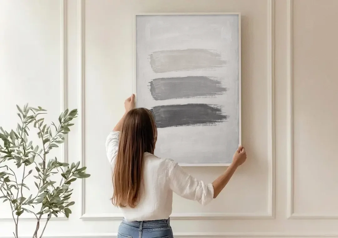 Black and White Stacked Brush Stroke Trio canvas wall art being hung on a paneled wall