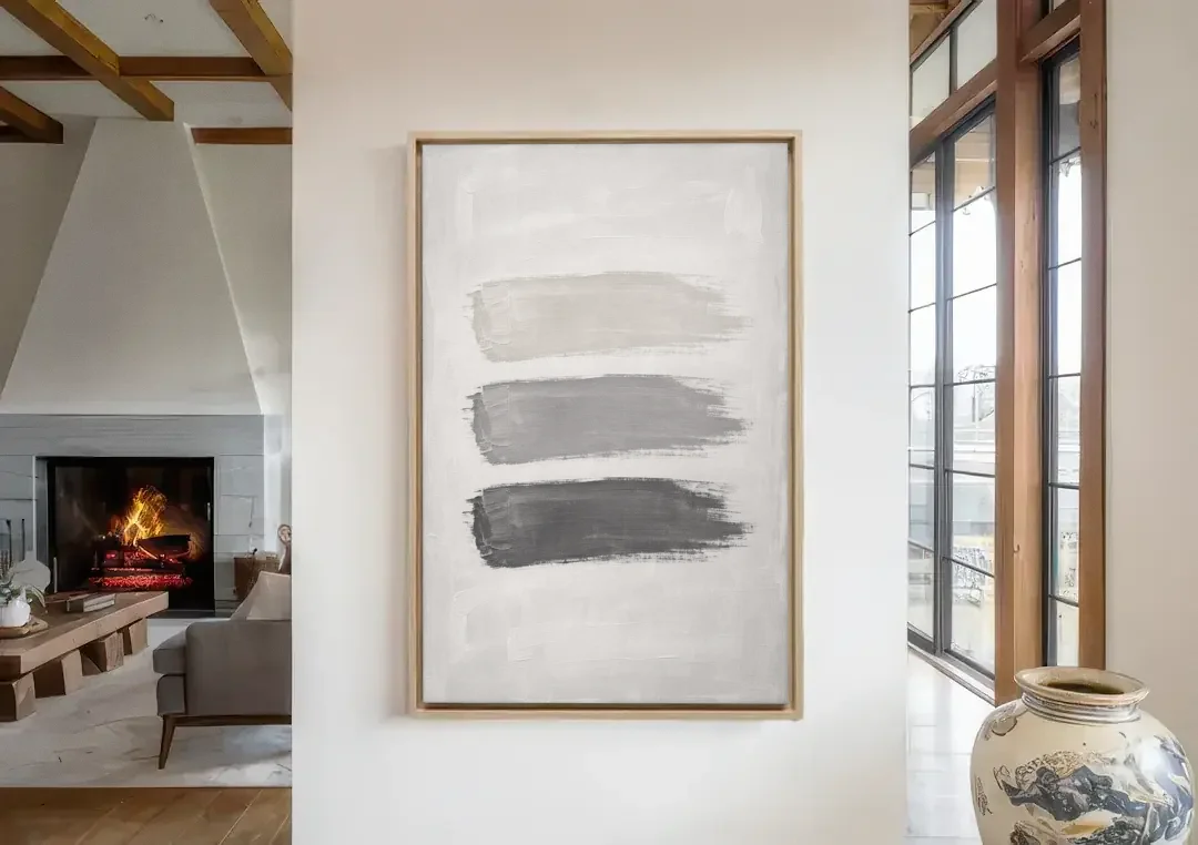 Black and White Stacked Brush Stroke Trio canvas wall art in a living room with a fireplace