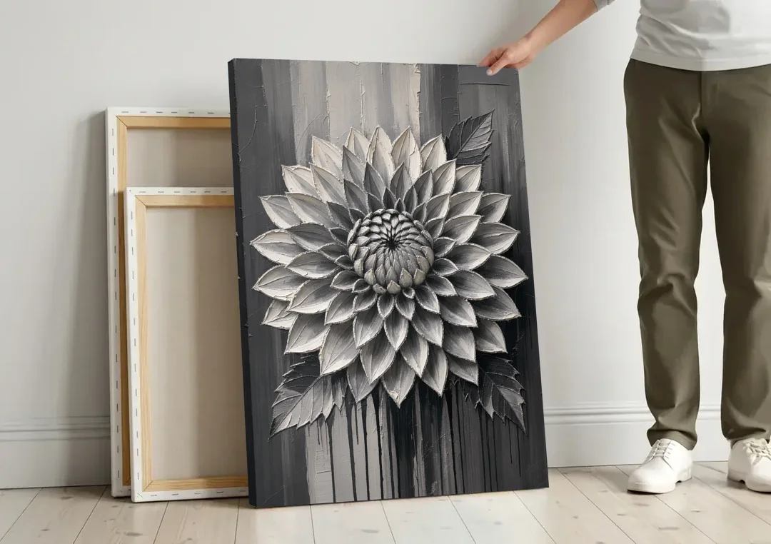 Black and White Textured Wall Art of a Dahlia canvas wall art leaning against a wall next to blank canvases