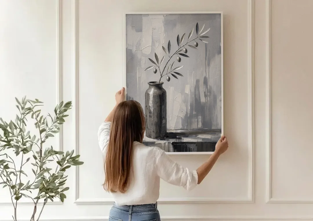 Black and White Vase Painting with Olive Branch canvas wall art being hung on a paneled wall