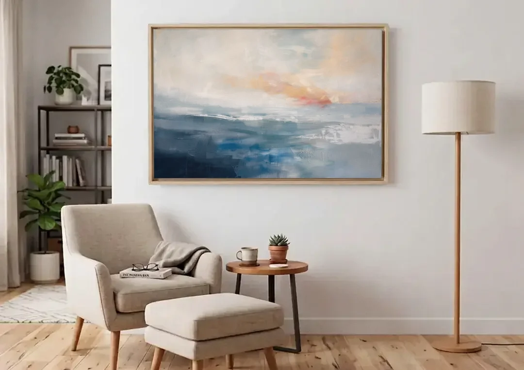 Blue Abstract Painting of a Misty Dawn Horizon canvas wall art above an armchair in a bright living room