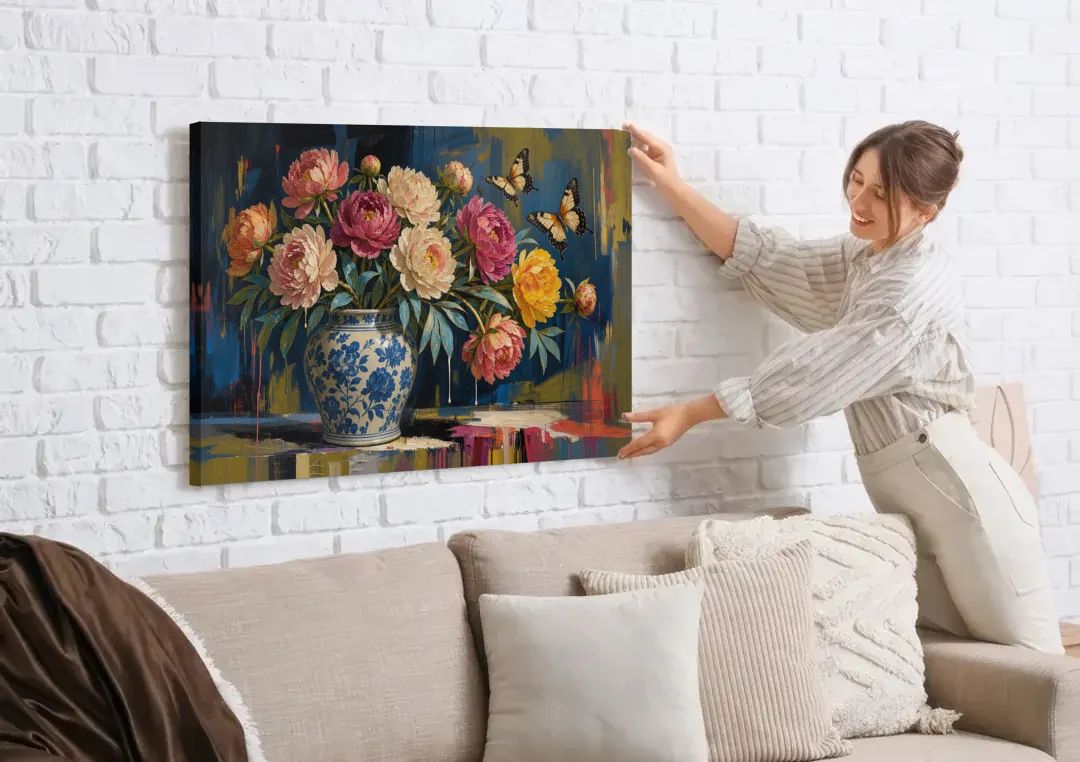 Blue and White Vase Painting With Peonies and Butterflies canvas wall art being hung on a white brick wall above a sofa