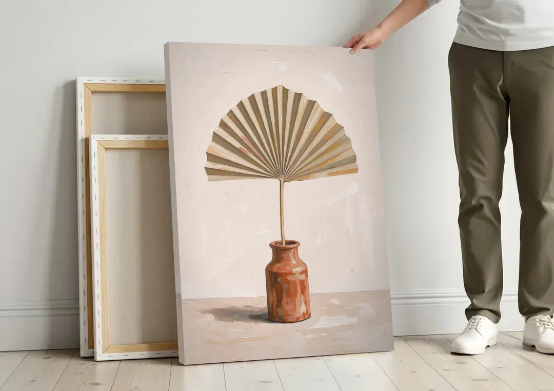 Boho Art Prints Fan Palm in a Clay Bottle canvas wall art leaning against a wall next to blank canvases