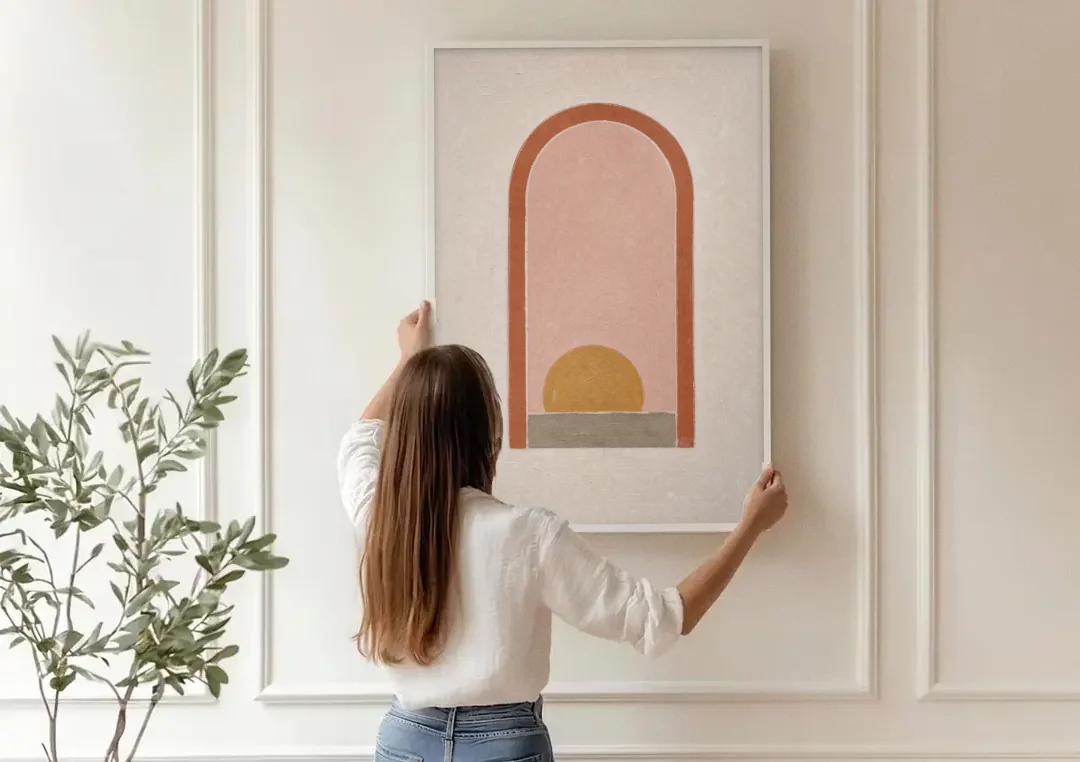 Boho Entryway Decor with Sun in a Tall Arch canvas wall art being hung on a paneled wall