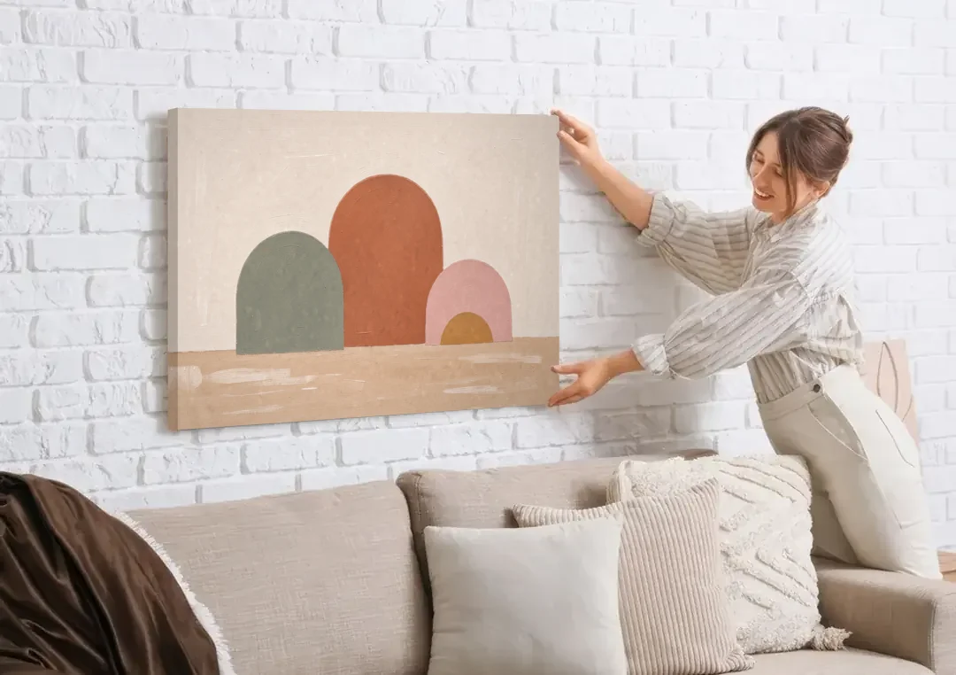 Boho Living Room Wall Art with Three Painted Arches canvas wall art being hung on a white brick wall above a sofa