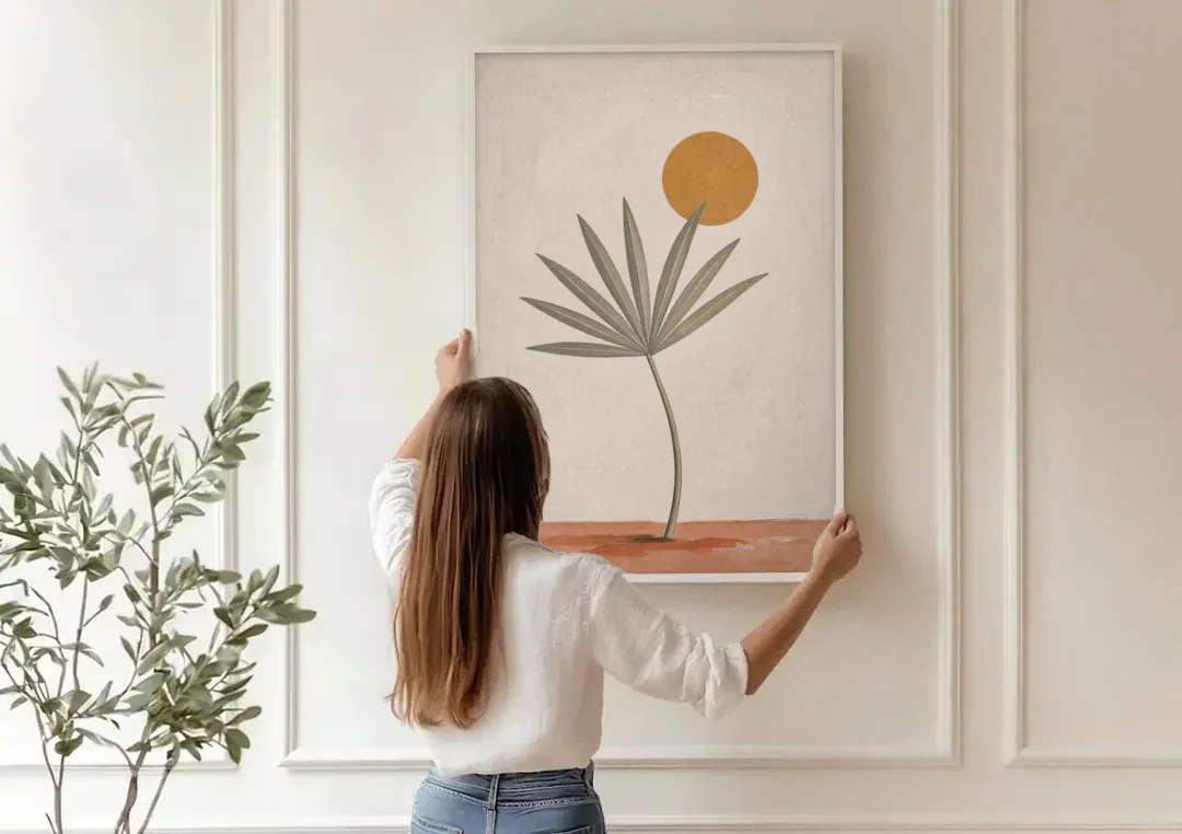 Boho Sun Over a Sage Palm Leaf canvas wall art being hung on a paneled wall