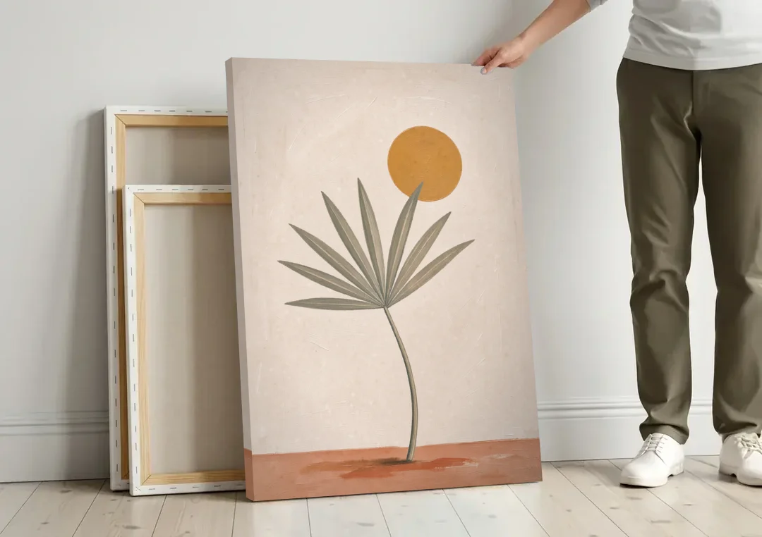 Boho Sun Over a Sage Palm Leaf canvas wall art leaning against a wall next to blank canvases
