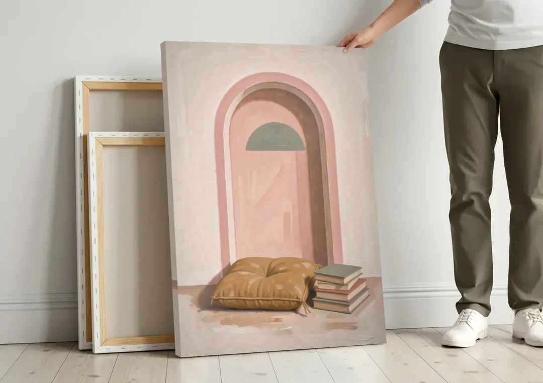 Book Nook Decor with Mustard Cushion in Blush Arch canvas wall art leaning against a wall next to blank canvases