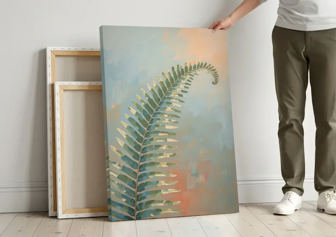 Botanical Arching Fern Frond in Early Light canvas wall art leaning against a wall next to blank canvases
