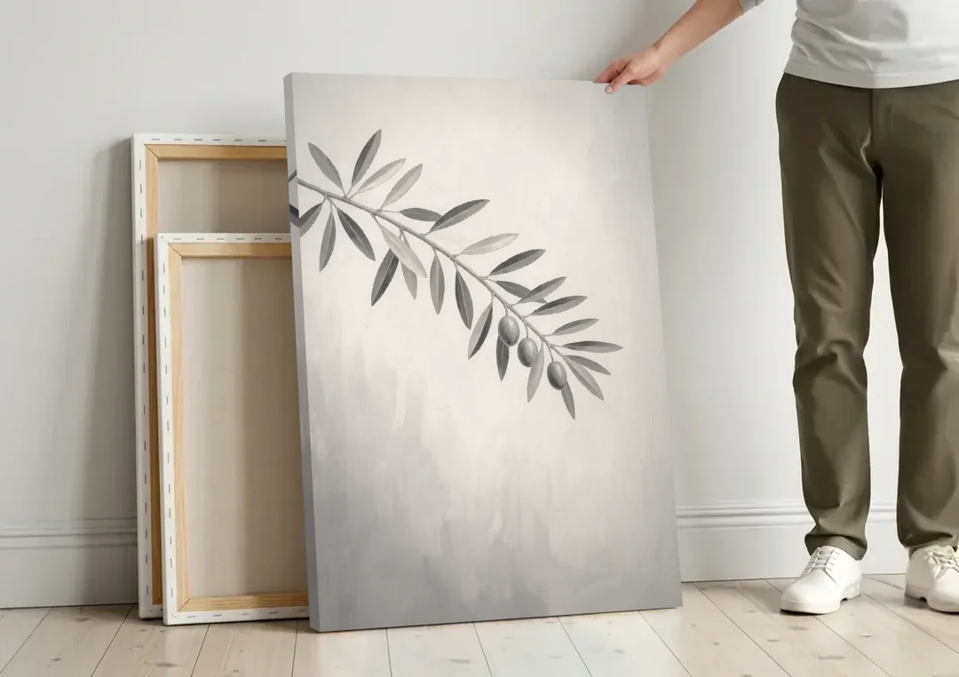 Botanical Paintings Olive Branch in Soft Grey canvas wall art leaning against a wall next to blank canvases